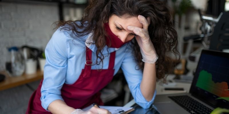 how-can-merchant-cash-advances-help-your-business-recover-after-covid-19 frustrated female business owner in cafe restaurant researching funding options